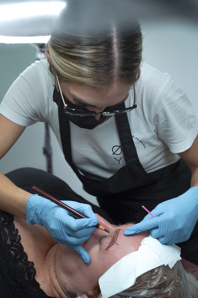 Chica haciendo microblanding a una mujer